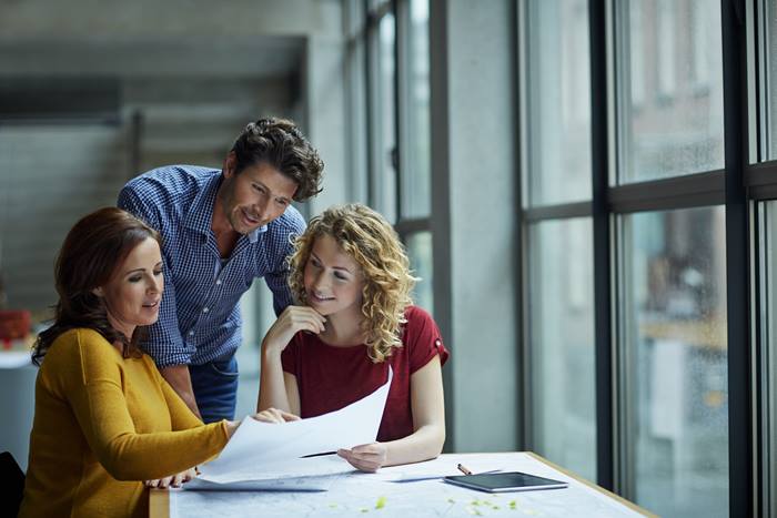 Three people reviewing paper